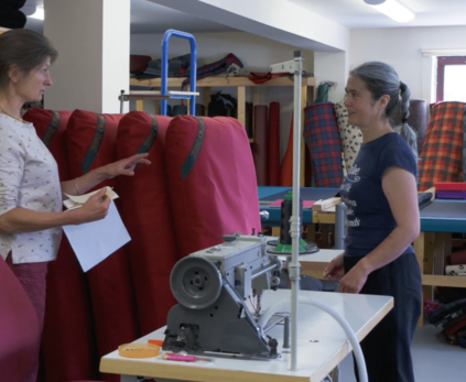 Two women stand in the Tuffies workshop discussing orthopaedic mattress dog beds.